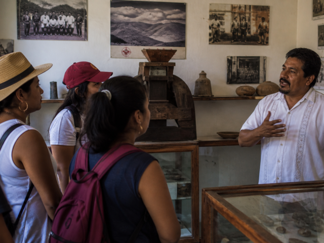 Visitantes observan fotografías y objetos históricos en un museo comunitario mexicano