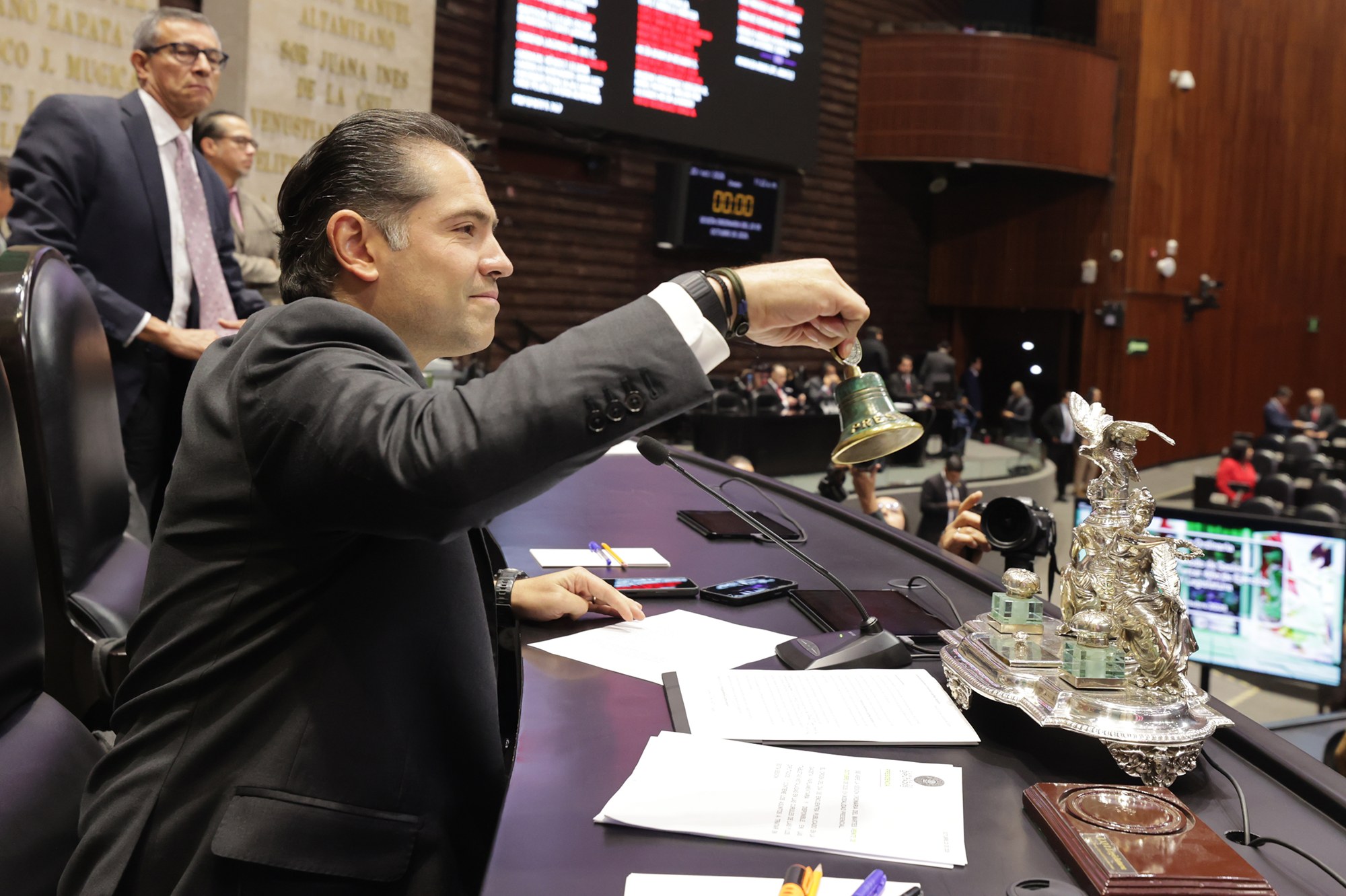 Legislador de la Cámara de Diputados toca la campana en la mesa de la Presidencia